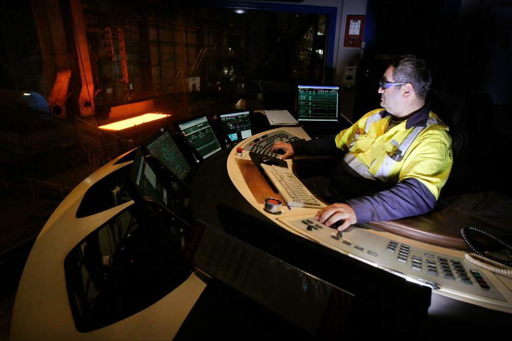 Adam Nicolaidis oversees a steel slab from the plate mill control room.